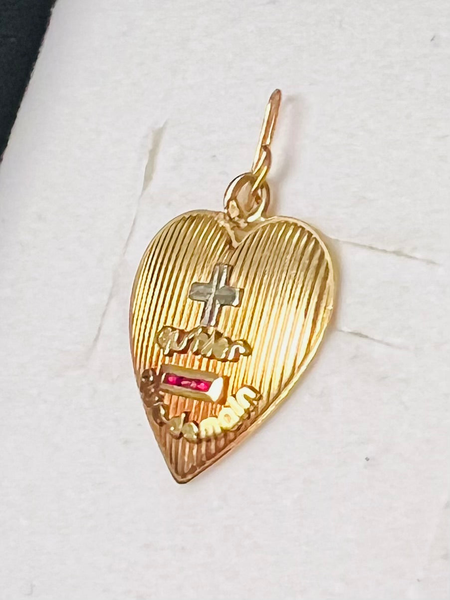 Pendentif Augis d’amour « + qu’hier - que demain » en or 18 carats serti de rubis calibrés.