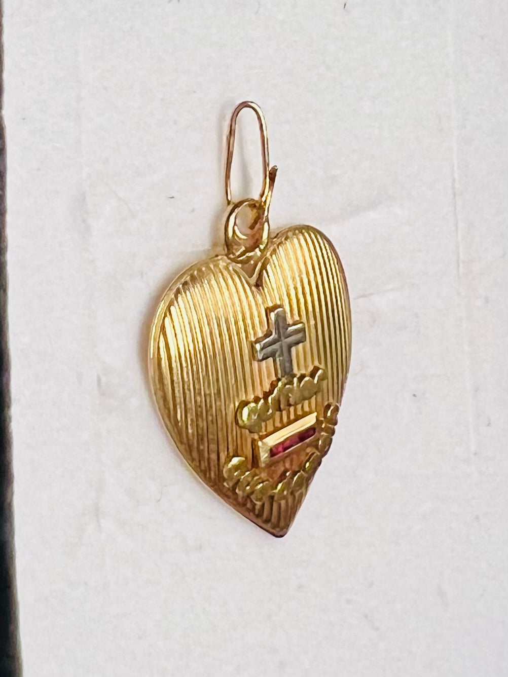 Pendentif Augis d’amour « + qu’hier - que demain » en or 18 carats serti de rubis calibrés.